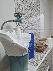 a bathroom counter with a bucket of towels and a sink at שקיעות מדבר in Yeroẖam