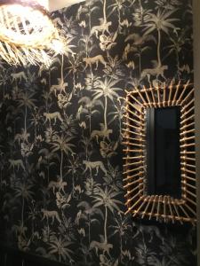 a mirror on a wall with a black and white wallpaper at BnB Montacutain in Montaigu-Vendée