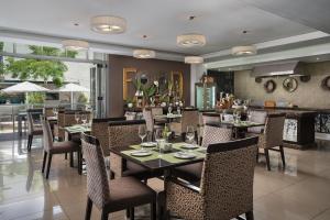 a dining room with tables and chairs in a restaurant at Protea Hotel by Marriott Upington in Upington