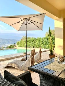 um pátio com uma mesa e cadeiras e uma piscina em Aggelos and Thisbe Chania Suburbs Sea View Guest House em Chania