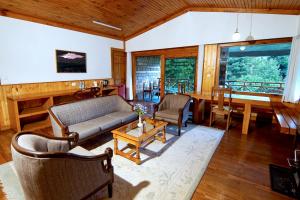 a living room with a couch and a table at Banon Resorts in Manāli