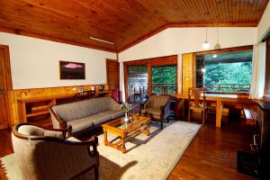 a living room with a couch and a table at Banon Resorts in Manāli