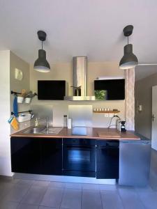 Sarrola-CarcopinoにあるAppartement cosy climatisé dans résidence ferméeのシンクとカウンタートップのあるキッチン