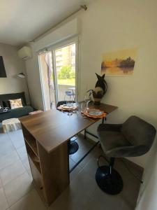 Habitación con escritorio, silla y ventana. en Appartement cosy climatisé dans résidence fermée, en Sarrola-Carcopino