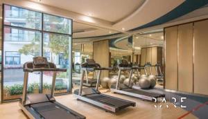 a gym with two exercise machines in a building at Rare Holiday Homes - Modern apartment - Near EXPO City - Desert view in Dubai