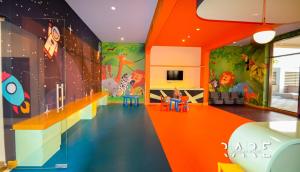 a childrens room with an orange wall with a dinosaur mural at Pool View - Near Expo 2020 - Ultra Modern Studio in Dubai