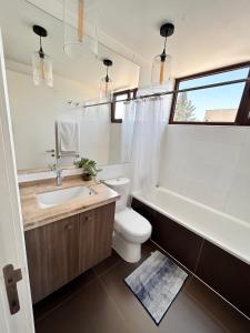 a bathroom with a toilet and a tub and a sink at Casa amoblada Chicureo Santiago in Colina