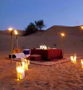 uma mesa no deserto com velas na areia em Hilton Jaisalmer Desert camp em Sām