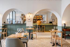 a restaurant with tables and chairs and a bar at Le Ph&eacute;nix H&ocirc;tel in Lyon