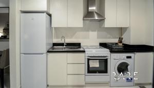 a white kitchen with a stove and a sink at Spacious Studio APT - Near Expo 2020 - Dubai South R410 in Dubai