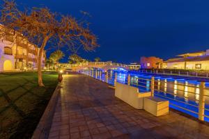 a person standing next to a river at night at Pickalbatros Dana Beach Resort - Aqua Park in Hurghada