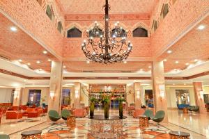 un gran vestíbulo con una lámpara de araña, mesas y sillas en Pickalbatros Dana Beach Resort - Aqua Park, en Hurghada
