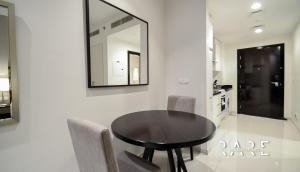 a dining room table with chairs and a mirror on a wall at Rare Holiday Homes offers Luxurious apartment with desert View - Near Expo City - R451 in Dubai