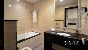 a bathroom with a sink and a mirror and a tub at Rare Holiday Homes offers Luxurious apartment with desert View - Near Expo City - R451 in Dubai