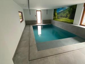 a swimming pool in a room with a painting on the wall at Villa Franzen in Derenbach