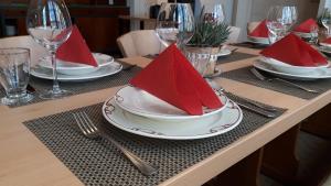 una mesa con platos con servilletas rojas. en Villa Franzen en Derenbach