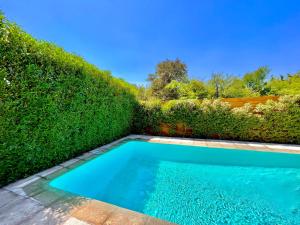 a swimming pool in front of a hedge at Casa amoblada Chicureo Santiago in Colina