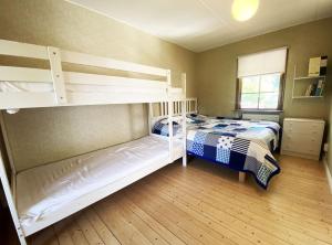 VejbystrandにあるCozy accommodation within walking distance to the seaのベッドルーム1室(二段ベッド2台、窓付)が備わります。