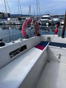 a white boat in a marina with other boats at Dejaté acunar por nuesto velero in Sitges