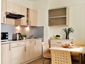 a kitchen with wooden cabinets and a table with bread on it at Apartamenty Media Park in Warsaw