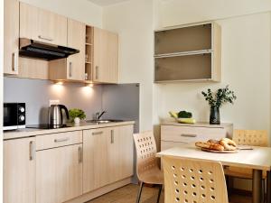 una cocina con armarios de madera y una mesa con pan. en Apartamenty Media Park, en Varsovia