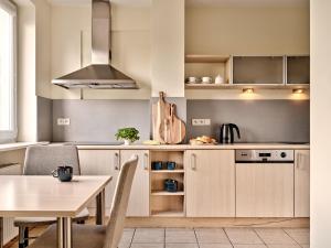 a kitchen with wooden cabinets and a table at Apartamenty Media Park in Warsaw