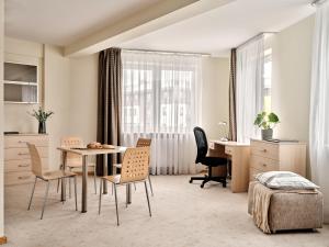 Apartamenty Media Park في وارسو: غرفة معيشة مع طاولة وكراسي ومكتب