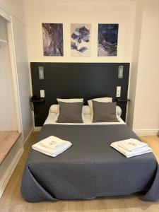 1 dormitorio con 1 cama con 2 toallas en Hotel Du Dauphiné, en Lyon