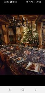 een lange tafel met borden eten en een kerstboom bij La Calvélène in Gerponville