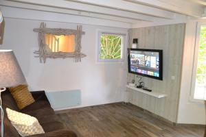 ein Wohnzimmer mit einem Sofa und einem Flachbild-TV in der Unterkunft maison atypique cosy Disneyland Paris/la vallée village/parking in Esbly