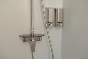 y baño con ducha y puerta de metal. en Villa Conde en Hospitalet de Llobregat