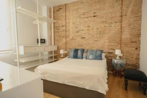 - une chambre avec un lit et un mur en briques dans l'établissement Villa Conde, à L'Hospitalet de Llobregat
