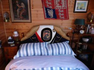 ein Schlafzimmer mit einem Bett mit einem Kostüm an der Wand in der Unterkunft NELSONS CABIN in North Creake