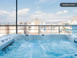 a hot tub on a balcony with a view of a city at Sanders Home Suites in Athens