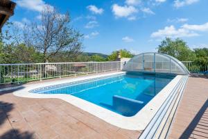a swimming pool with a greenhouse next to a house at Horrio in Querol +16 photos