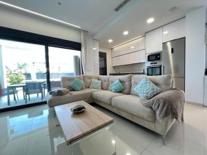 een woonkamer met een bank en een tafel bij Villa Deluxe La Marina Beach in Alicante