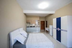 a small room with a bed and a kitchen at Milestone City - Appartements à louer in Antananarivo