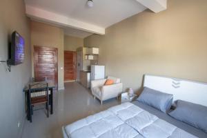 a bedroom with a bed and a couch and a chair at Milestone City - Appartements à louer in Antananarivo