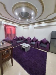 un soggiorno con divani viola e tavolo di Saraya Eltram-families only ad Alessandria d'Egitto