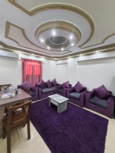 a living room with purple couches and a table at Saraya Eltram-families only in Alexandria