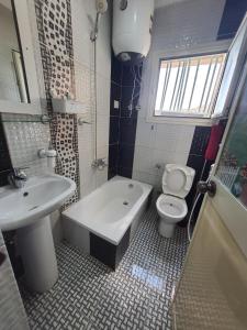 La salle de bains est pourvue de toilettes, d'une baignoire et d'un lavabo. dans l'établissement Saraya Eltram-families only, à Alexandrie