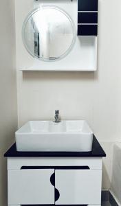 La salle de bains est pourvue d'un lavabo blanc et d'un miroir. dans l'établissement chaithanya wellness centre, à Vagamon