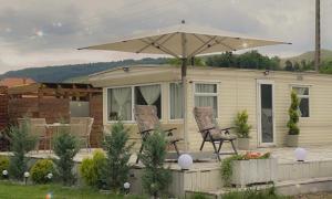 una casa con due sedie e un ombrellone di Kinder Valley Morlaca Cluj a Cluj-Napoca