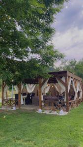 un pabellón de madera con mesa y sillas en un campo en Kinder Valley Morlaca Cluj, en Cluj-Napoca