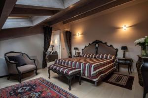 a bedroom with a large bed and a chair at Hotel Residenza la Ceramica in Fabriano