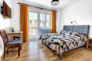a bedroom with a bed and a desk and a window at Willa Wladyslaw - centrum Krynicy, parking w cenie! in Krynica Zdrój
