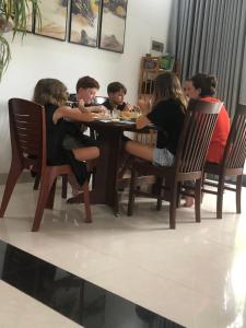 um grupo de pessoas sentadas à volta de uma mesa em Aba Travel Villa em Hoi An
