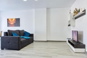 ein Wohnzimmer mit einem Sofa und einem TV in der Unterkunft Apartamente Nord 10 in Năvodari