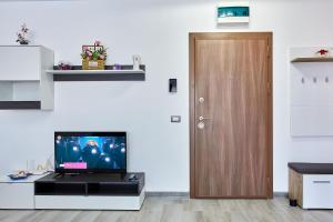 ein Wohnzimmer mit einem TV und einer Holztür in der Unterkunft Apartamente Nord 10 in Năvodari