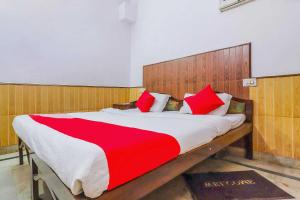 - une chambre avec un grand lit et des oreillers rouges dans l'établissement Flagship Hotel Prem Chunaria, à Moradabad